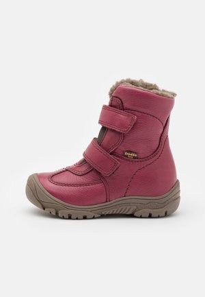 Botte d’hiver en cuir rose pour enfant, avec deux bandes velcro, semelle beige et doublure en polaire beige douce visible en haut.