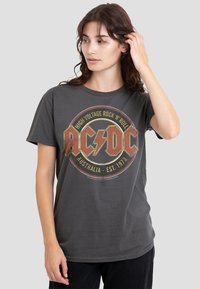 Gray cotton t-shirt featuring a circular AC/DC graphic in red, yellow, and black. Crew neck, relaxed fit, short sleeves.