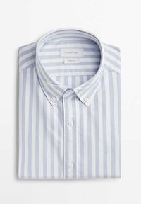 Chemise à rayures verticales bleu clair et blanc avec col boutonné, soigneusement pliée sur un fond blanc.