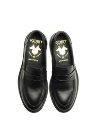 Chaussures en cuir noir à enfiler avec une finition lisse, présentant une large bande sur le cou-de-pied et des détails de couture subtils. Logo doré sur la semelle intérieure.