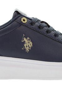 Marineblaue Ledersneaker mit weißer Gummisohle, runder Zehenpartie und goldfarbenem Logoakzent. Enthält graue Schnürsenkel und metallische Ösen.