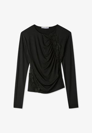 Top nero a maniche lunghe con tessuto drappeggiato su un lato e dettagli in pizzo sulla spalla e sul petto. Tessuto liscio su tutta la superficie.
