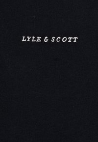 Czarna bawełniana tkanina z haftem "LYLE & SCOTT" w kolorze białym. Tekstura jest gładka, o prostym i czystym wzorze.