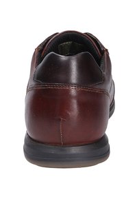 Brązowy skórzany but z zaokrąglonym tyłem, charakteryzujący się teksturowanym wierzchem, kontrastowym przeszyciem oraz trwałą czarną gumową podeszwą.