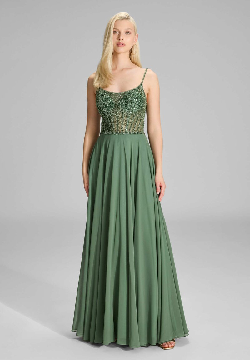 Robe de soirée longue verte avec un corsage perlé, des bretelles fines et une jupe en chiffon fluide. Le tissu semble lisse avec un éclat subtil.