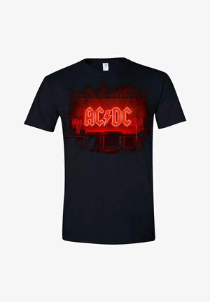Schwarzes Baumwoll-T-Shirt mit einem lebhaften roten AC/DC-Logo und einem Blitz im Hintergrund einer Bühne, mit kurzen Ärmeln und Rundhalsausschnitt.