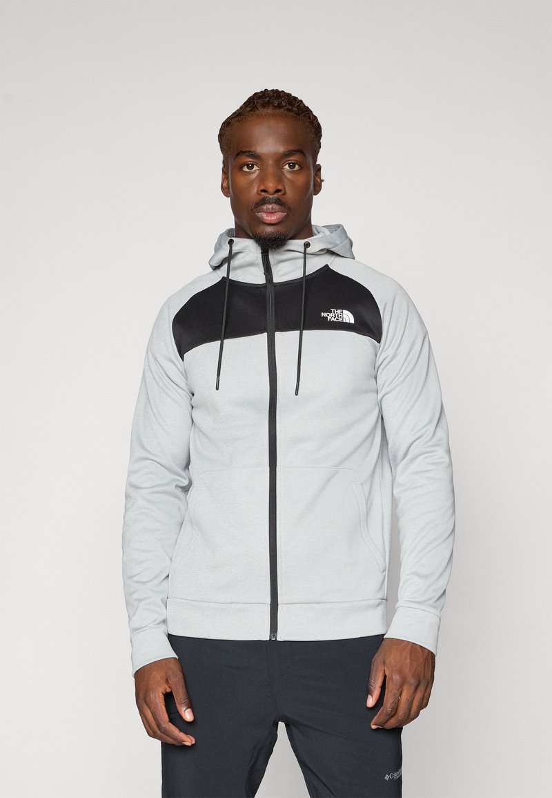 Grey zip-up hooded sweatshirt with black accents and logo. Features drawstrings, a smooth texture, and side pockets.