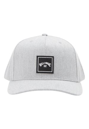 Lichtgrijze Billabong baseballpet met gebogen klep en een zwart vierkant logo-patch in het midden aan de voorkant.