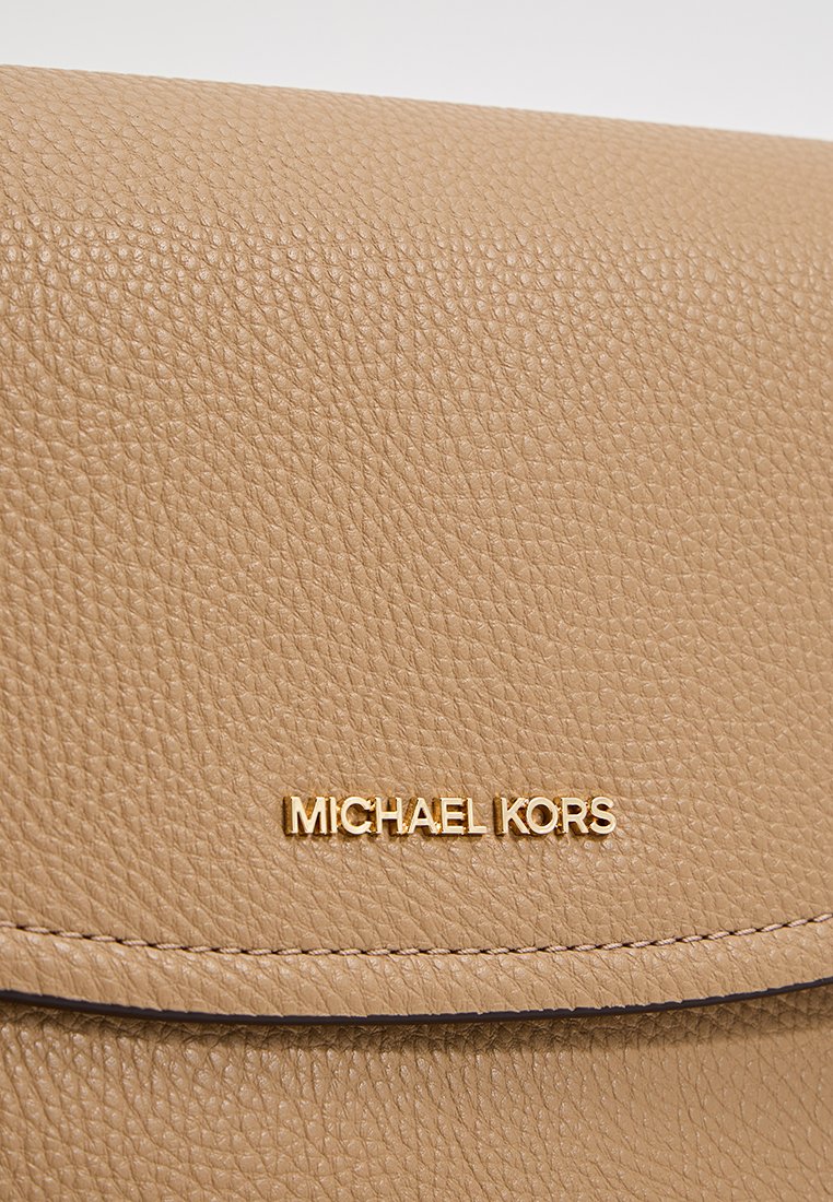 Beige leren handtas met een gestructureerd oppervlak, voorzien van een goudkleurig "MICHAEL KORS" logo. Vouwflap sluiting met een gestikte rand.