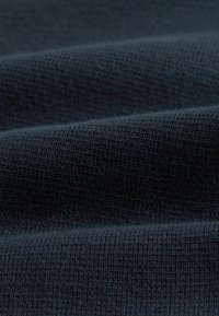 Dunkelblauder strukturierter Stoff mit einem weichen, gestrickten Aussehen, der sanfte Rippungen und eine glatte Oberfläche aufweist.