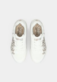 White athletic sneakers featuring a mesh upper, perforated detailing, and a brown decorative stitching pattern on the side.