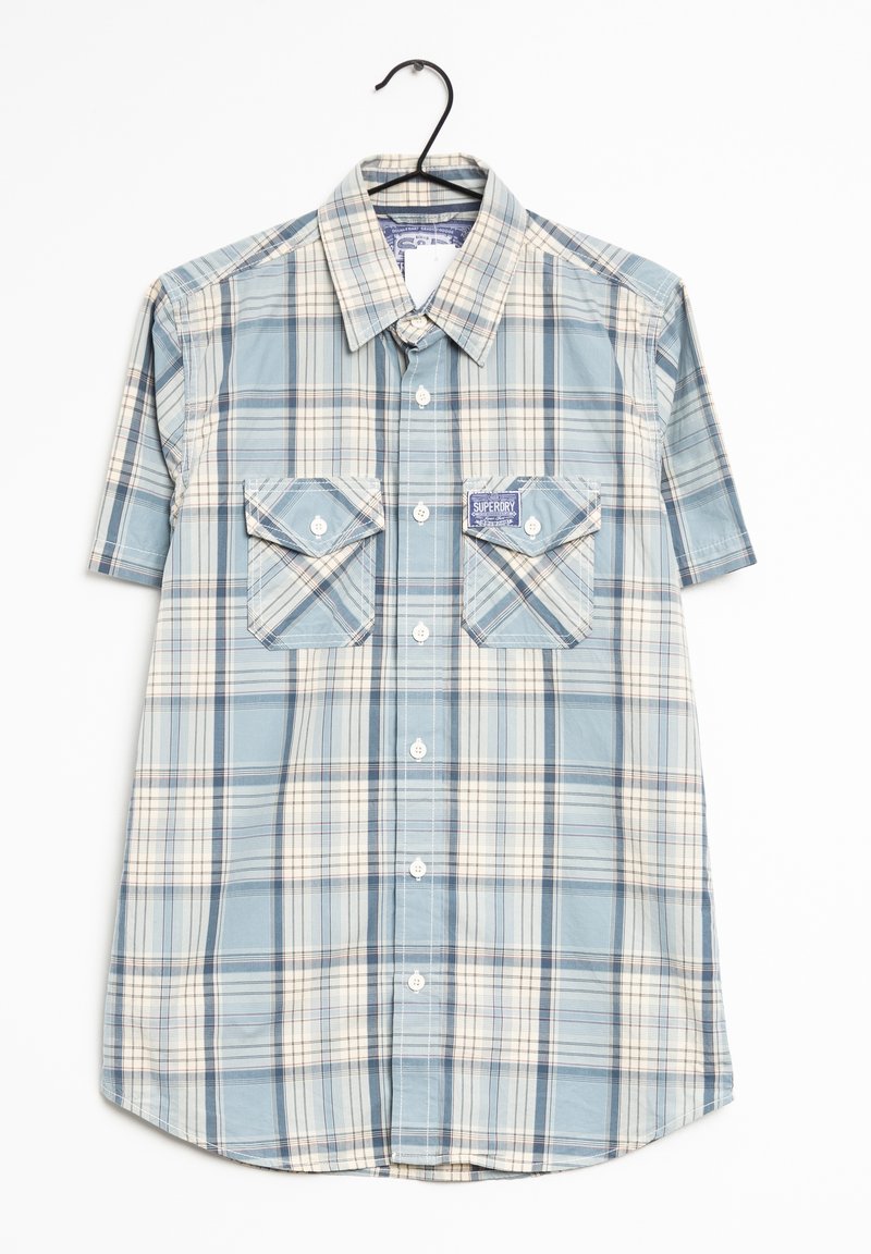 Chemise à manches courtes à carreaux dans des tons bleus, crème et gris, dotée de deux poches poitrine et d'un col boutonné. Texture de tissu lisse.