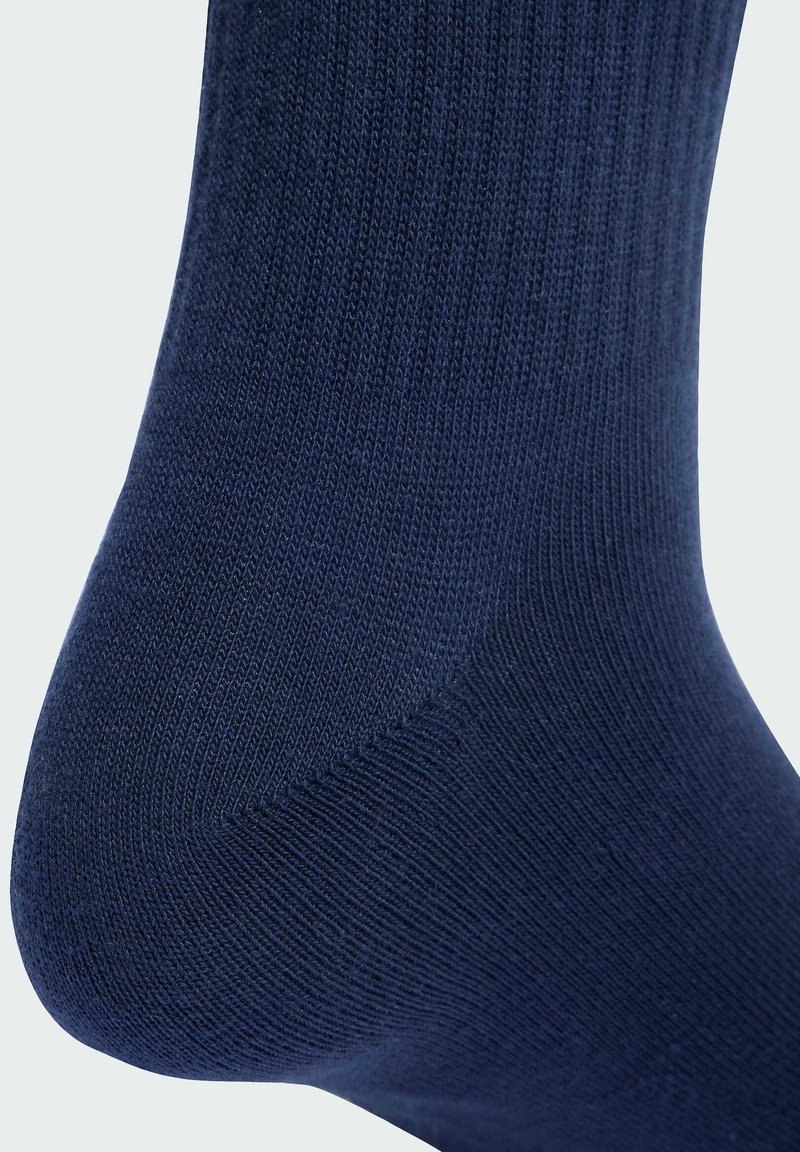 Marineblå sok med ribbet tekstur og forstærket hæl. Fremstillet af et blødt materiale for komfort og holdbarhed, med en glat finish.
