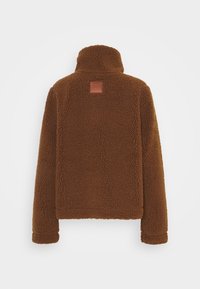 Brun fleecejakke med høj krave, lange ærmer og et lille læderpatch centreret på den øverste del af ryggen.