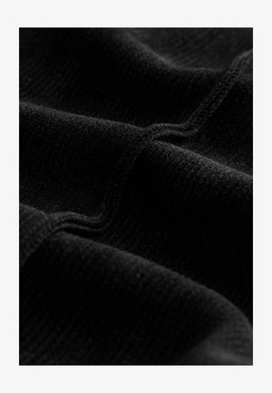 Prim-plan al unei țesături negre texturate, cu cusături vizibile și pliuri delicate care evidențiază modelul său țesut și suprafața sa pufoasă.