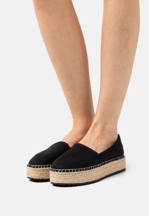 Černé espadrilky s plátěnou podešví ze sazby, s vlněnou juteovou platformou, nabízející design na zaklínění a silnou, texturovanou podrážku.