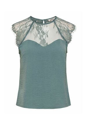 Blouse sans manches couleur sarcelle avec des manches courtes en dentelle et une encolure en dentelle florale transparente au-dessus d'un décolleté en forme de cœur.