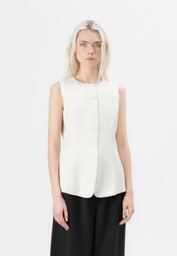 Light beige, sleeveless linen vest with a round neckline and six button closures. Features a fitted design and side pockets.