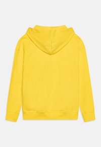 Hoodie di cotone giallo visto da dietro, dotato di una tasca a marsupio, polsini a costine e cappuccio con cordino. Texture liscia e colore vivace.