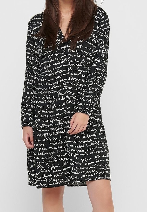 Vestido negro con un patrón de escritura a mano. Mangas largas y diseño de escote en V. Fabricado en una tela ligera con un ajuste relajado.