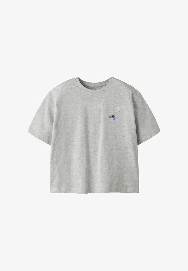 T-shirt gris clair à manches courtes et col rond avec une petite broderie florale violette et blanche sur le côté gauche de la poitrine.