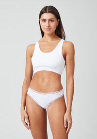 Witte katoenen bralette met een ronde halslijn en een ondersteunende band. Bijpassende witte panties met kanten randen en een lage taille.
