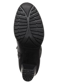 Suola di stivale in pelle nera con un grip strutturato e motivo, con punta arrotondata e design a tacco piatto. La costruzione robusta è evidente.