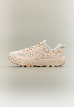 Zapatilla de trail running en rosa claro y blanco con suela acolchada y agarre Vibram, vista lateral sobre fondo neutro.