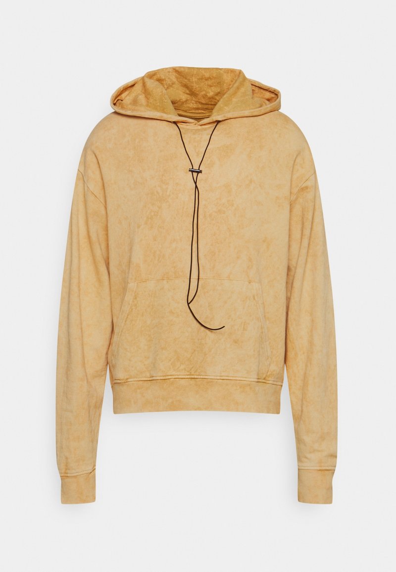 Sweat à capuche marron clair délavé avec manches longues, poche kangourou à l'avant et cordons noirs suspendus à la capuche.