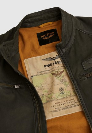 Veste en cuir vert foncé avec doublure orange, comportant une étiquette PME Legend et une carte vintage du service de fret aérien imprimée à l'intérieur.