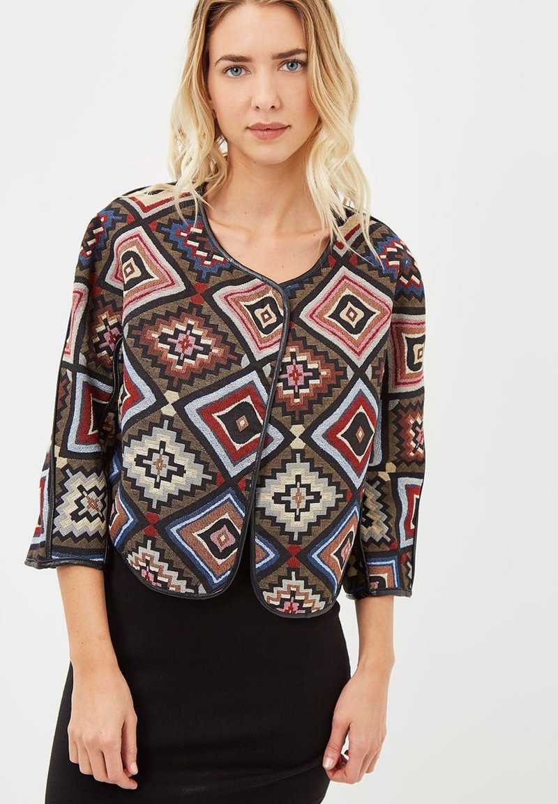 Chaqueta corta con un diseño geométrico en tonos rojos, azules y beiges, con mangas de tres cuartos y un cuello redondeado.