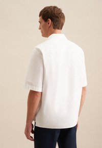 Witte short-sleeve shirt van lichtgewicht stof. Het heeft een klassieke kraag en een licht gebogen zoom, wat zorgt voor een ontspannen pasvorm.
