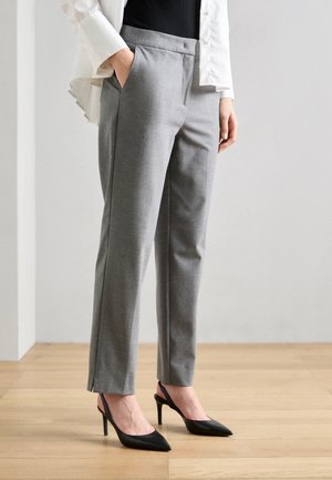 Gray tailored trousers with side pockets, smooth texture, and a straight fit, paired with black pointed-toe heels.