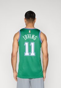 Πράσινη φανέλα μπάσκετ με μπλε περιθώριο, με λευκά γράμματα "IRVING" και τον αριθμό "11" στην πλάτη. Υφή από δίχτυ, χωρίς μανίκια.