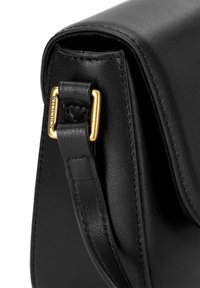 Černá kožená kabelka s hladkou texturou, vybavená zlatě tónovaným kovovým popruhem a klopňovým uzavíráním. Čisté linie a minimalistický design.
