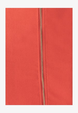 Rød stof med en fremtrædende lynlås langs siden, med en metallisk finish. Teksturen ser glat og jævn ud.