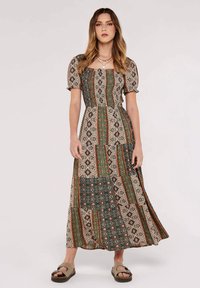 Robe maxi dans un motif patchwork avec des nuances de verts, bruns et crèmes. Manches courtes bouffantes et décolleté carré. Tissu doux et fluide.