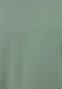 Zelené tričko s krátkým rukávem z hladké, jednobarevné látky. Má klasický kulatý výstřih s rovnoměrným texturou a bez viditelných vzorů nebo akcentů.