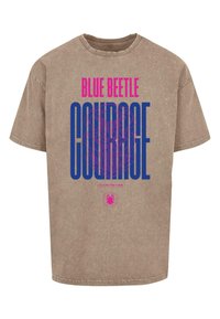 Camiseta de algodón marrón con la llamativa frase "BLUE BEETLE" en rosa y "COURAGE" en azul, con detalles gráficos del logo y un corte relajado.