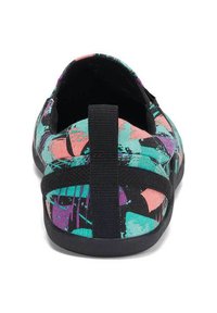 Canvas-slipon med ett flerfärgat abstrakt mönster i turkos, svart, rosa och lila; har en svart elastisk rem bakom.