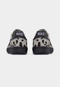 Nike superge imajo zasnovo v sivi in črni barvi z teksturirano zgornjo površino, črnimi poudarki in pikčastim vzorcem na peti.