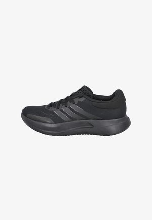 Zapato deportivo negro con parte superior de malla texturizada, tres franjas gris oscuro, cuello acolchado y suela gruesa de goma para brindar soporte.