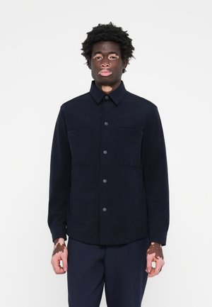 Navy blue work jacket in structured fabric. Features a button closure, two chest pockets, and a collar. Smooth texture, minimalistic design.