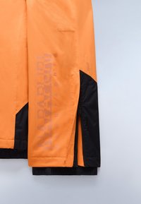Oranssi ja musta Napapijri Geographic -takki, jonka hihassa on vetoketjuyksityiskohta, vaaleanharmaalla taustalla.