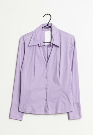 Camicia a maniche lunghe color lavanda con colletto a punta e orlo dritto, caratterizzata da bottoni abbinati e texture liscia.