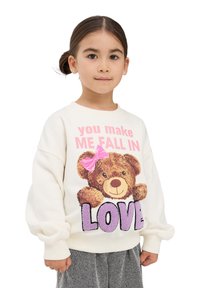 Biała bluza z kapturem z portretem niedźwiedzia w różowej kokardzie, tekstem "sprawiasz, że SIĘ ZAKOCHUJĘ" w purpurowym kolorze, z teksturowanymi akcentami.