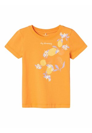 Camiseta de algodón naranja de manga corta, que presenta un diseño gráfico de frutas y flores en blanco y morado claro, con el texto "day dreaming" arriba.
