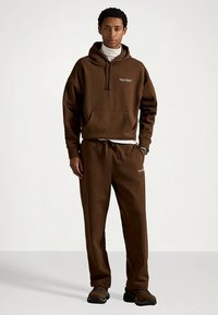 Καφέ φλις φούτερ με τσέπη μπροστά, κορδόνια και λογότυπο "POLO SPORT". Συνδυάζεται με καφέ φόρμα που ταιριάζει. Υφή υφάσματος.