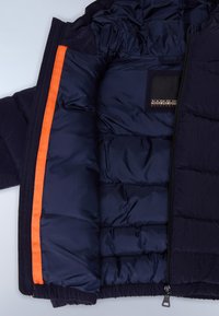 Marineblaue gesteppte Jacke mit offenem Reißverschluss, der orangefarbene Borte und ein Innenetikett mit der Aufschrift Napapijri Geographical zeigt.