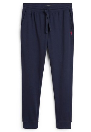 Marineblauwe katoenen joggers met een elastische tailleband, trekkoord, zijzakken en een klein rood logo op het linkerbeen. Gladde textuur.
